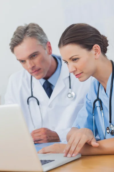 Two doctors focused on a laptop screen — Stock Photo, Image