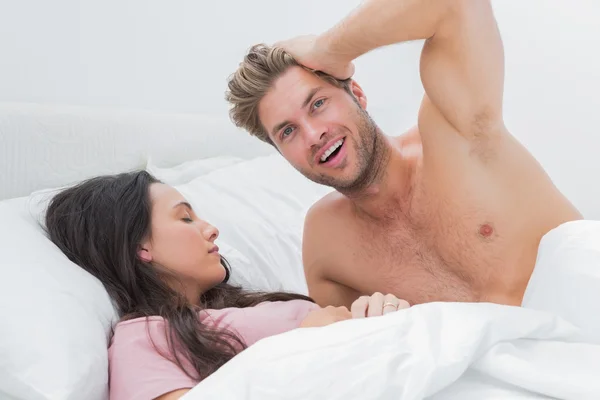 Un hombre sin camisa posando junto a su compañero de dormir —  Fotos de Stock