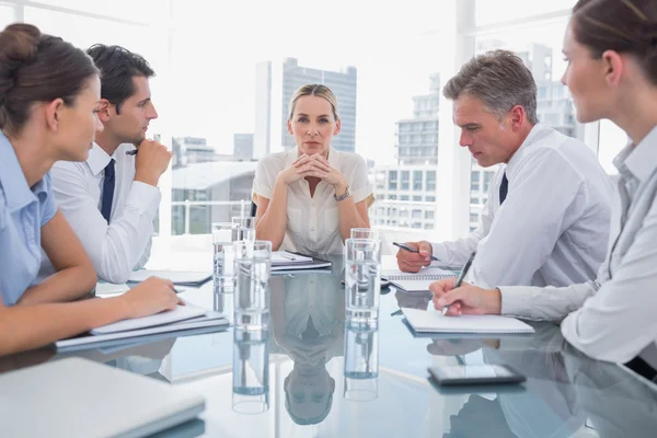 Serious businesswoman looking at camera with colleagues around — Stock Photo, Image