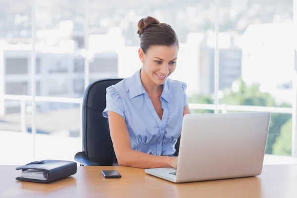 Donna d'affari felice che lavora sul suo computer portatile — Foto Stock