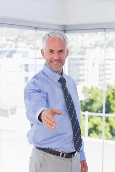 Uomo d'affari sorridente braccio di estensione per stretta di mano — Foto Stock