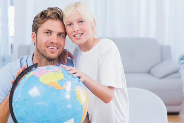 Vader en zoon kijken naar globe en glimlachen — Stockfoto