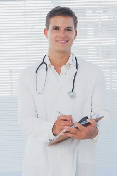 Médico bonito segurando uma área de transferência — Fotografia de Stock