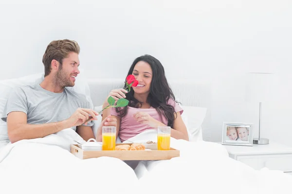 Pretty woman smelling a rose given by her husband — Stock Photo, Image