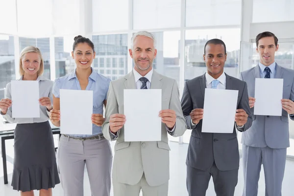 Buisness team holding up blank pages — Stock Photo, Image