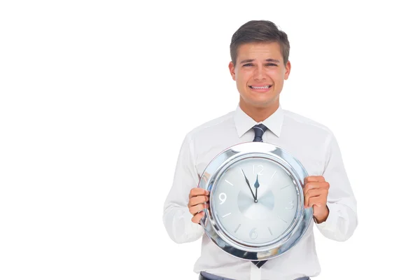 Besorgter Geschäftsmann hält Uhr — Stockfoto