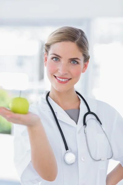 Mulher médico mostrando uma maçã — Fotografia de Stock