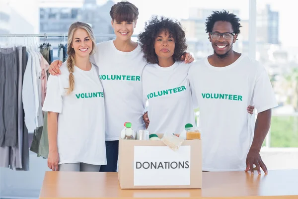 Freiwillige stehen vor Lebensmitteln in einer Spendenbox — Stockfoto