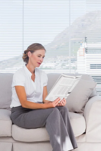 Fröhliche Geschäftsfrau entspannt sich und liest Zeitung — Stockfoto