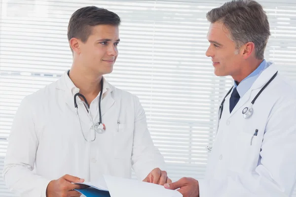 Smiling doctors holding a folder — Stock Photo, Image