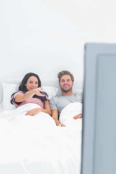 Woman changing channel in her bed — Stock Photo, Image