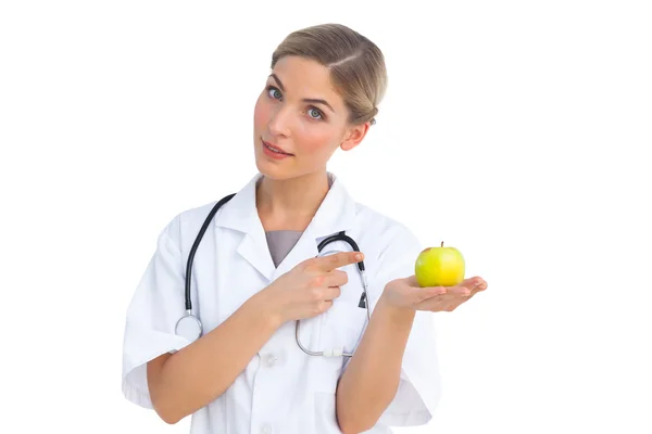 Nurse pointing to green apple on her hand — Stock Photo, Image
