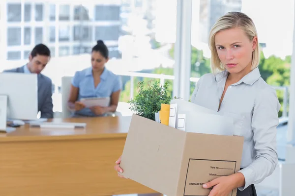 Businesswoman leaving office after being laid off and looking at camera — Stock Photo, Image