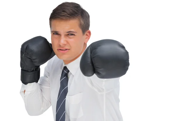 Empresário batendo com luvas de boxe preto — Fotografia de Stock
