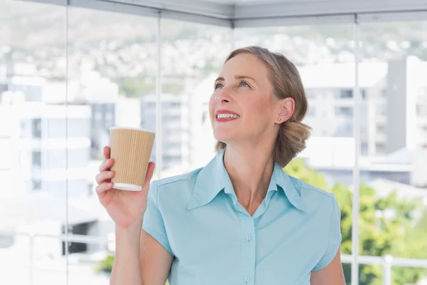 Donna d'affari in possesso di tazza di caffè usa e getta e guardando in alto — Foto Stock