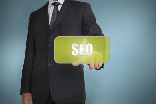 Businessman touching green tag with the word seo written on it — Stock Photo, Image