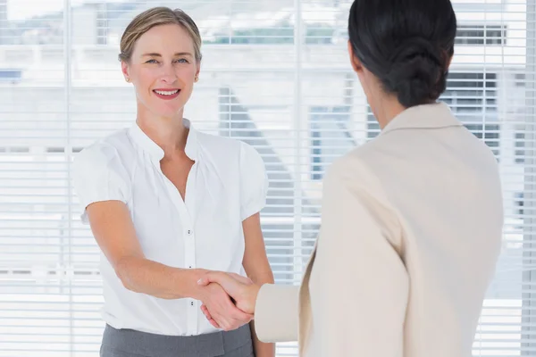 Businesswomen shaking hands in office — Stock Photo, Image