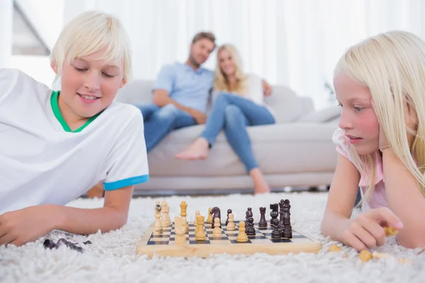 Дети играют в шахматы в гостиной — стоковое фото