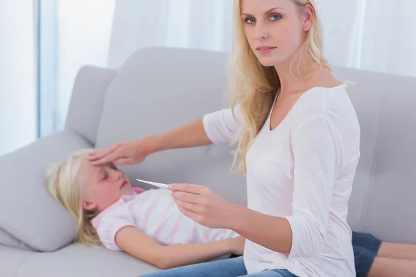 Mother taking her daughter's temperature — Stock Photo, Image