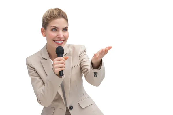 Businesswoman with microphone showing something — Stock Photo, Image