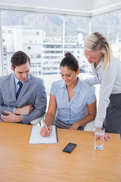 Happy businesswoman showing colleagues something on her notepad — Stock Photo, Image