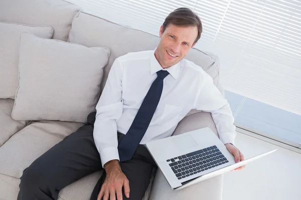 Empresário sorridente com um laptop — Fotografia de Stock