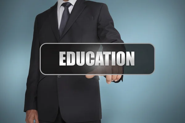 Businessman touching the word education written on black tag — Stock Photo, Image