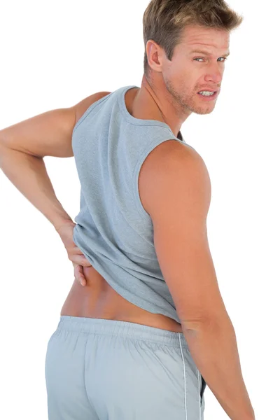 Muscled man grimacing because of a back pain — Stock Photo, Image