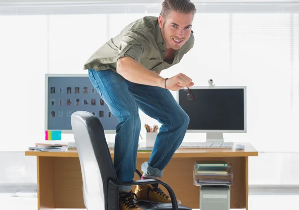 Sorrindo homem surfando sua cadeira de escritório — Fotografia de Stock