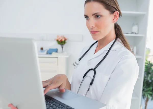 Médico mulher séria usando um laptop — Fotografia de Stock