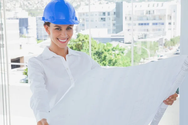 Cheerful architect rolling out a blueprint — Stock Photo, Image