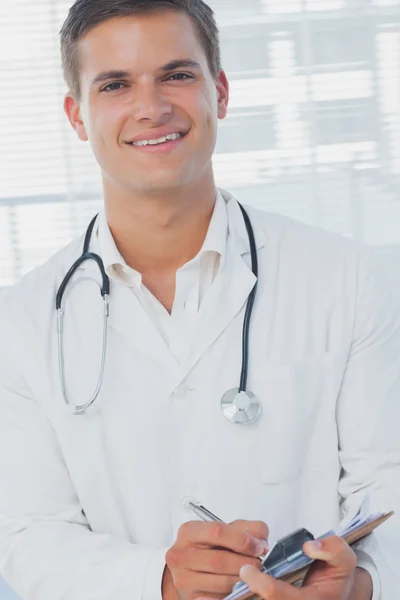 Handsome doctor holding pen — Stock Photo, Image