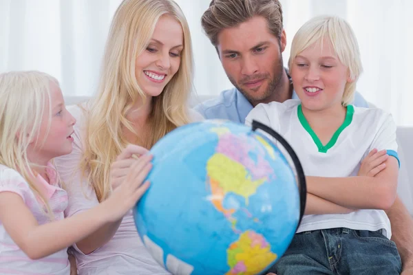 Família sorridente com globo — Fotografia de Stock