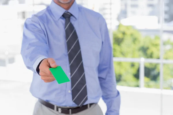 Бизнесмен предлагает зеленую визитную карточку — стоковое фото