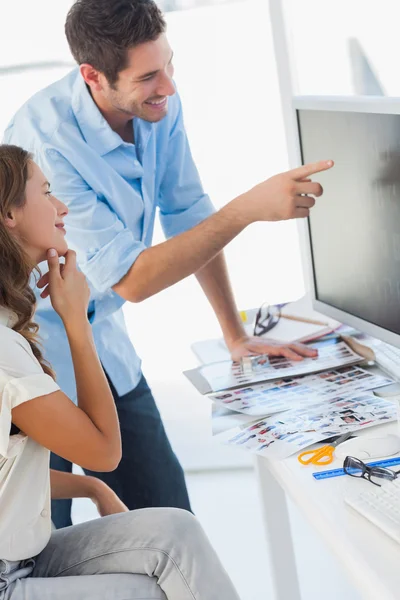 Editores de fotos alegres trabalhando juntos em um computador — Fotografia de Stock