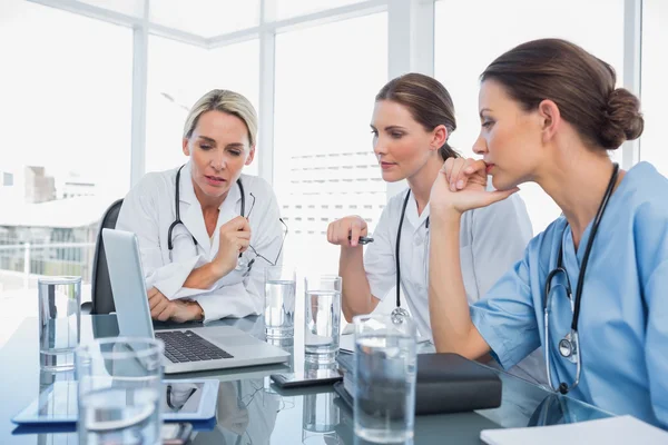 Três mulheres médicas assistindo um laptop — Fotografia de Stock