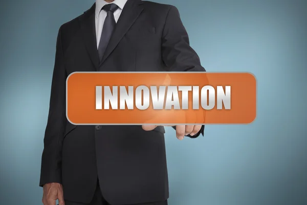 Businessman selecting the word innovation written on orange tag — Stock Photo, Image