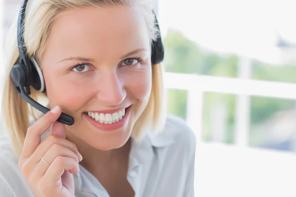 Zakenvrouw met headset glimlachen op camera — Stockfoto