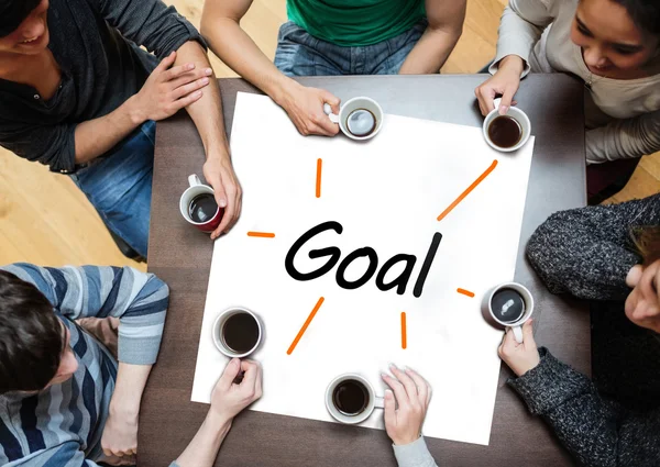 Team brainstorming over a poster with goal written on it — Stock Photo, Image