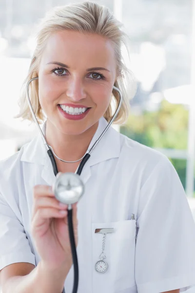 Infirmière souriante montrant son stéthoscope — Photo