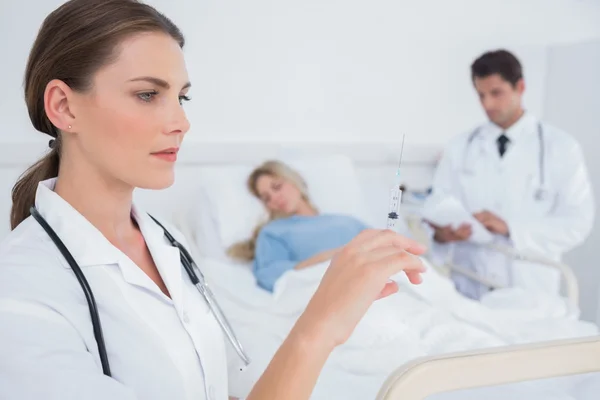 Médico sério segurando uma seringa — Fotografia de Stock