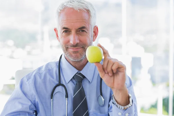 Läkaren håller ett äpple i handen — Stockfoto