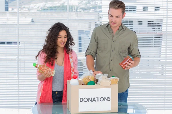 Volunteers taking out food from donations box — Stock Photo, Image