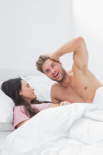 Knappe man poseren naast zijn partner van de slaap — Stockfoto