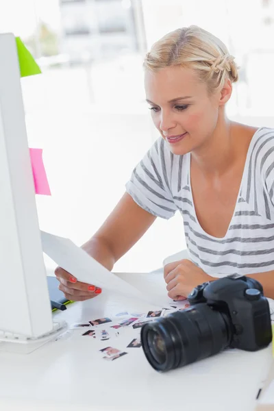 Vrolijke fotoredacteur kijken naar een contactblad — Stockfoto