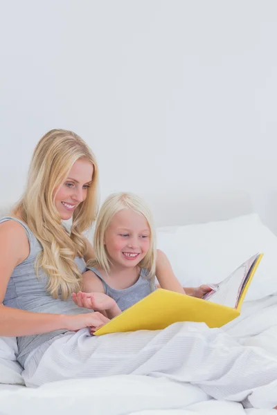 Alegre madre e hija leyendo una historia juntos — Foto de Stock