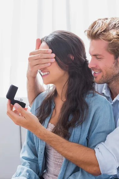 Hombre escondiendo esposas ojos para ofrecerle un anillo de compromiso — Foto de Stock