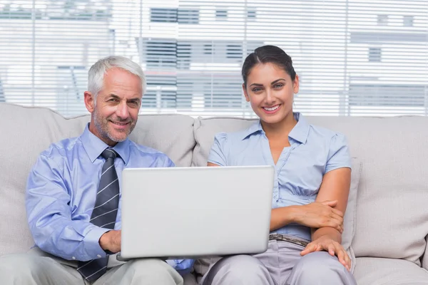 Business with laptop smiling at camera — Stock Photo, Image