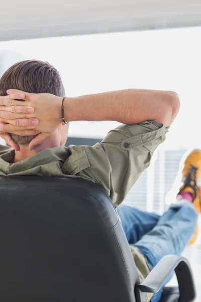 Rear view of a designer relaxing in a modern office — Stock Photo, Image