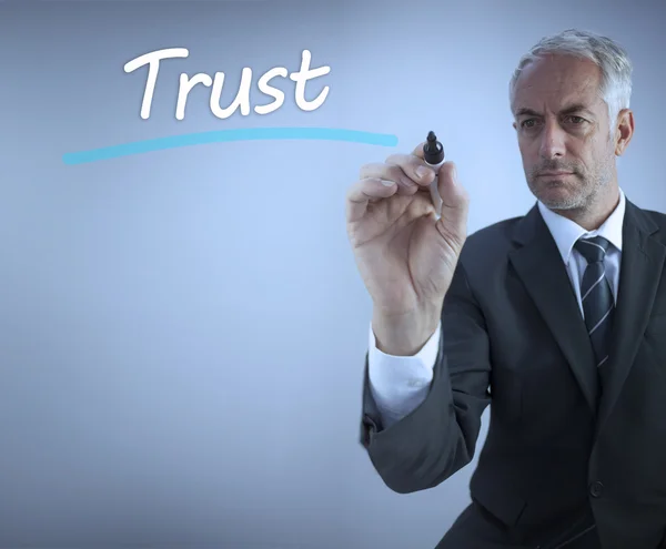 Empresário escrevendo a palavra confiança — Fotografia de Stock